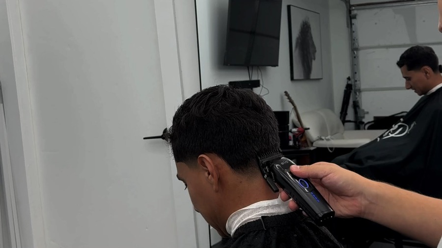 Barber trimming a client's hair inside The OR studio